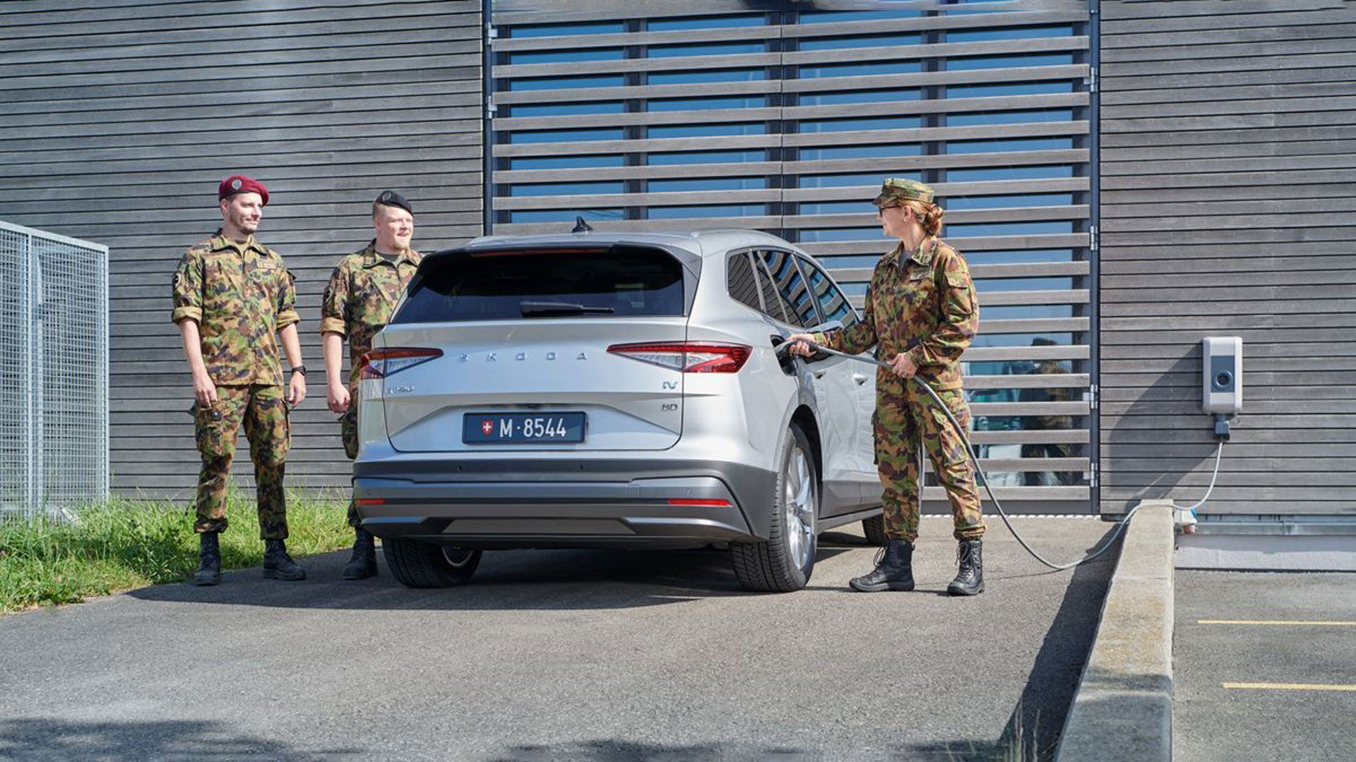 Un militaire de carrière recharge un véhicule électrique.